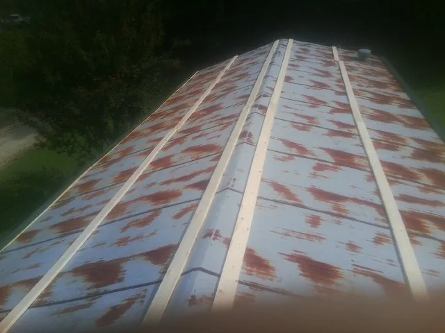 Rusted metal roof panels with new wood purlins before replacement — Storm Damage Roof Repair in Winter Park by Roofing Brothers