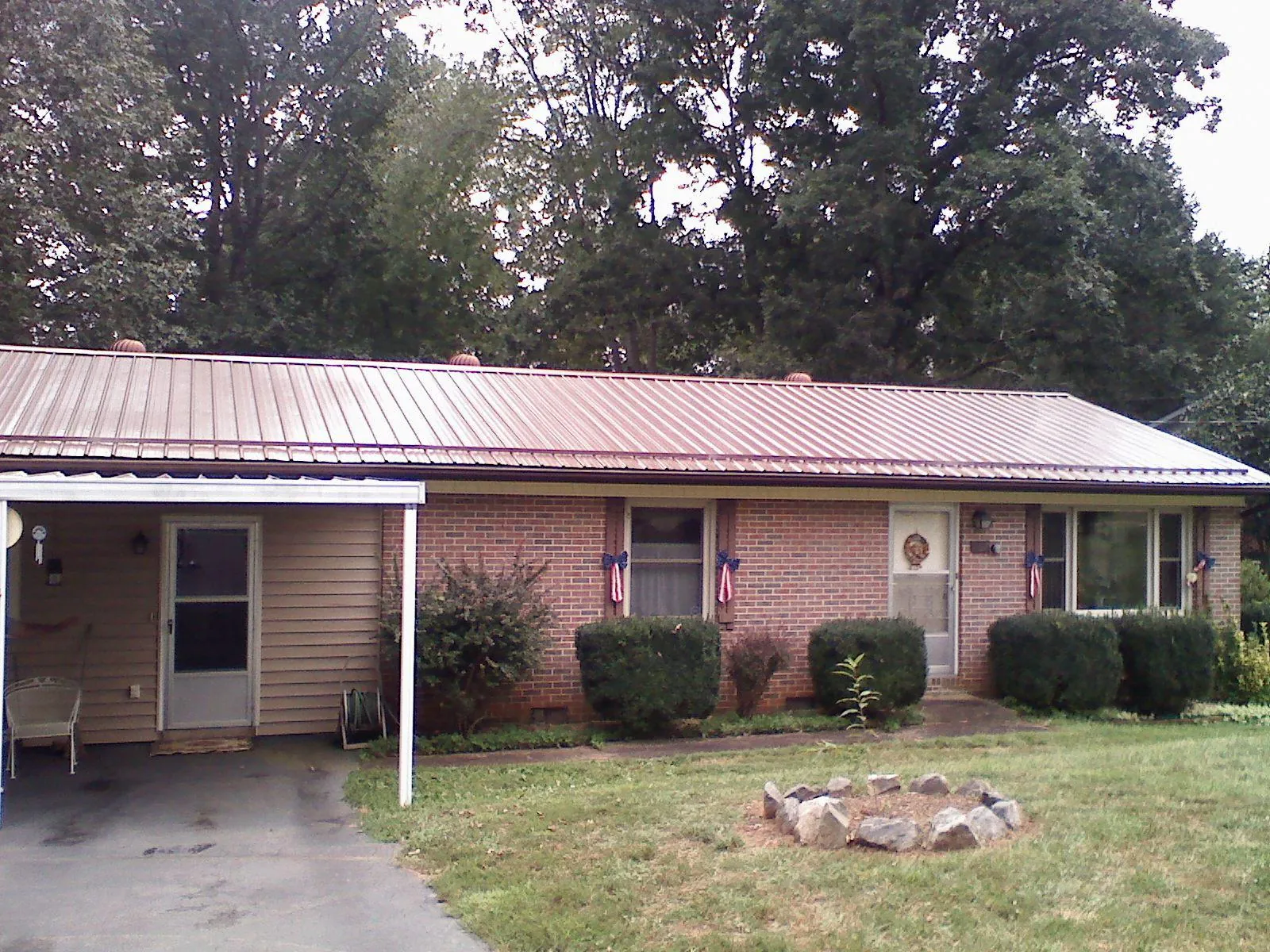 Bronze metal roof and carport on a brick ranch home — Roof Repair work by our crew in Winter Park